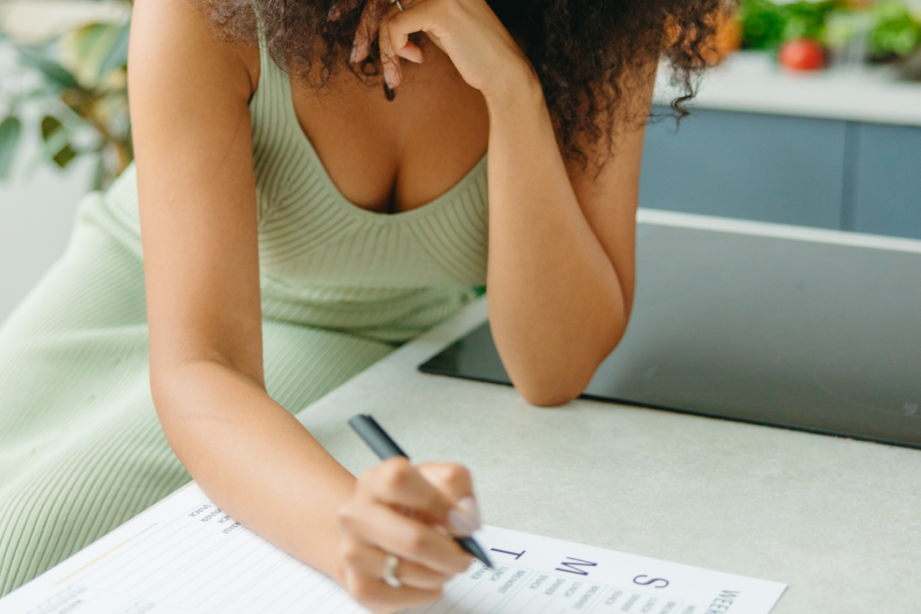 a woman writing a meal plan