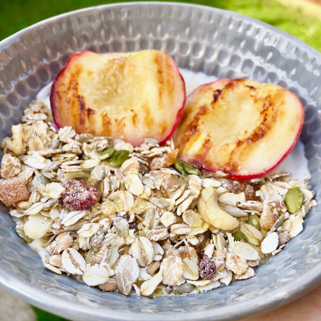 Close up view of peach and muesli yoghurt bowl