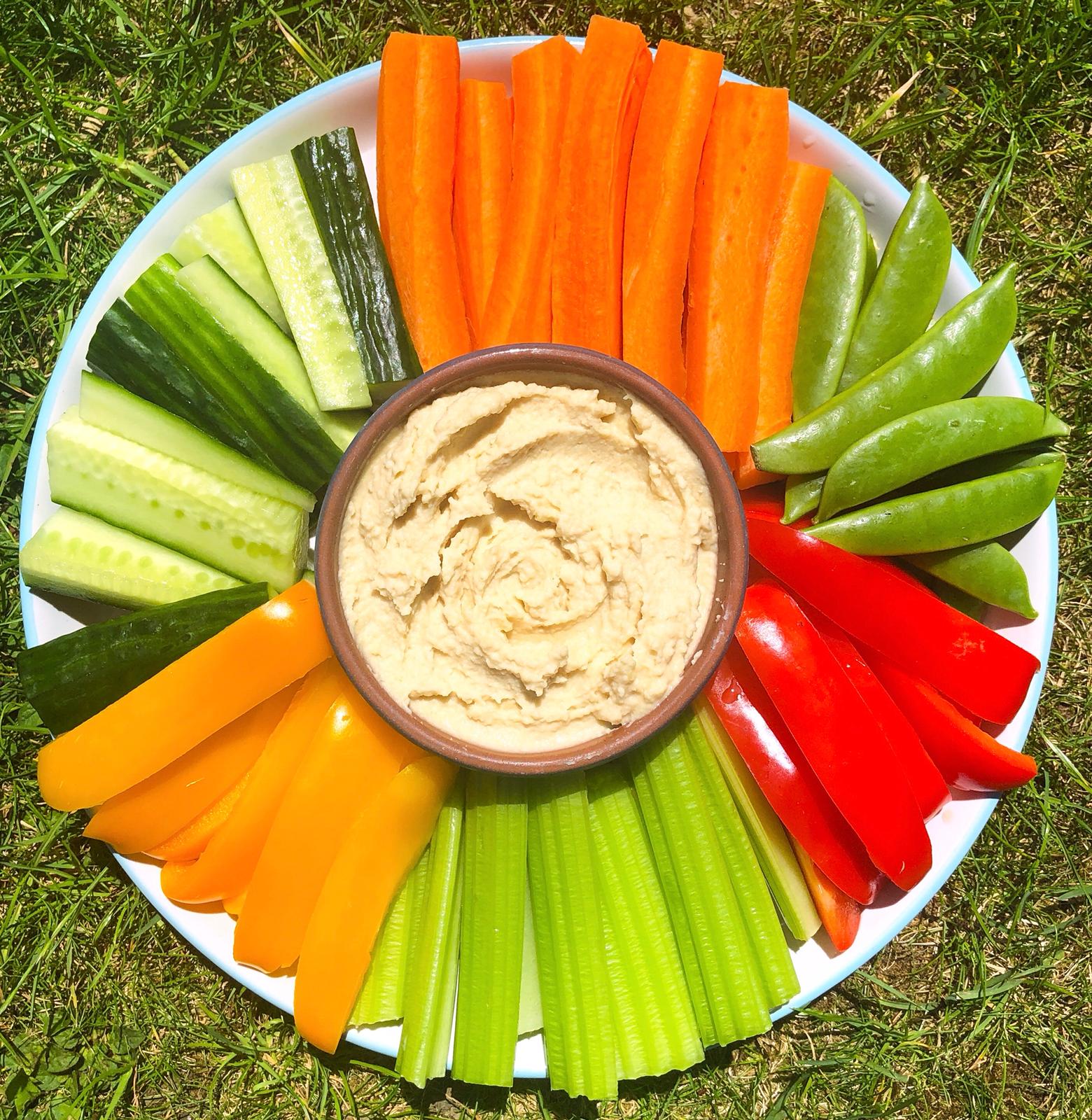 Butter bean hummus in a bowl surrounded by a variety of vegetable sticks