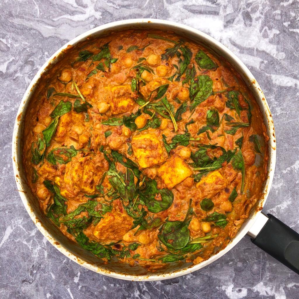 Overhead view of a pan of tofu, chickpea and cashew cream curry