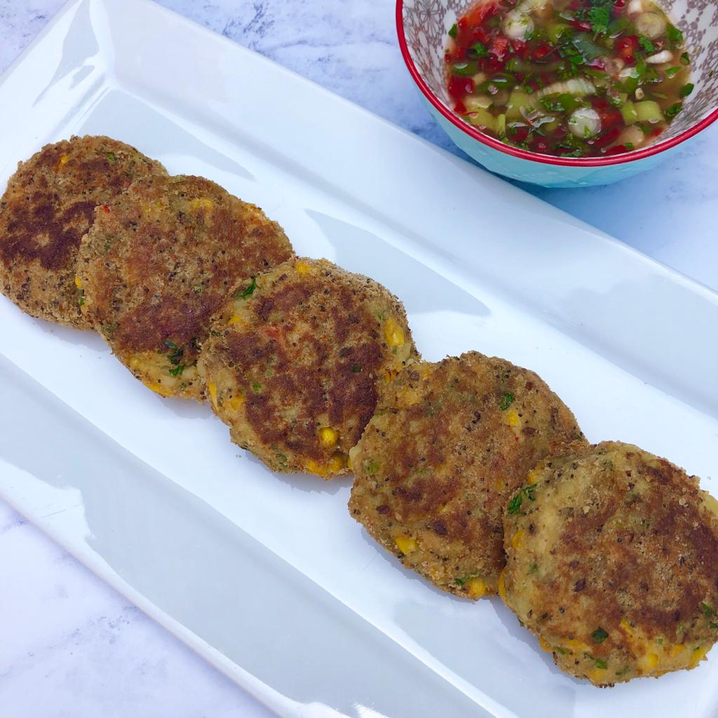 Plate of Thai style crab cakes served with a bowl of dipping sauce