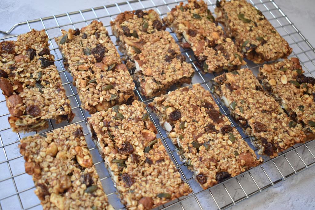 Granola bars with oats, seeds and fruit on a metal cooling rack