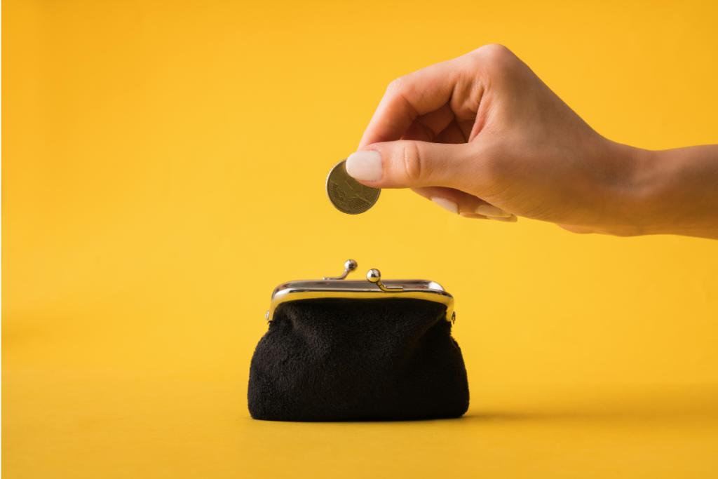 a woman's hand putting a coin into a purse