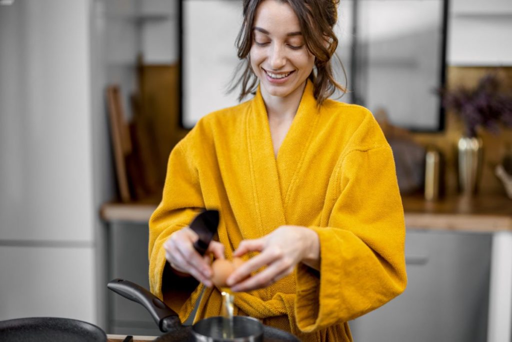 woman cooking eggs for breakfast