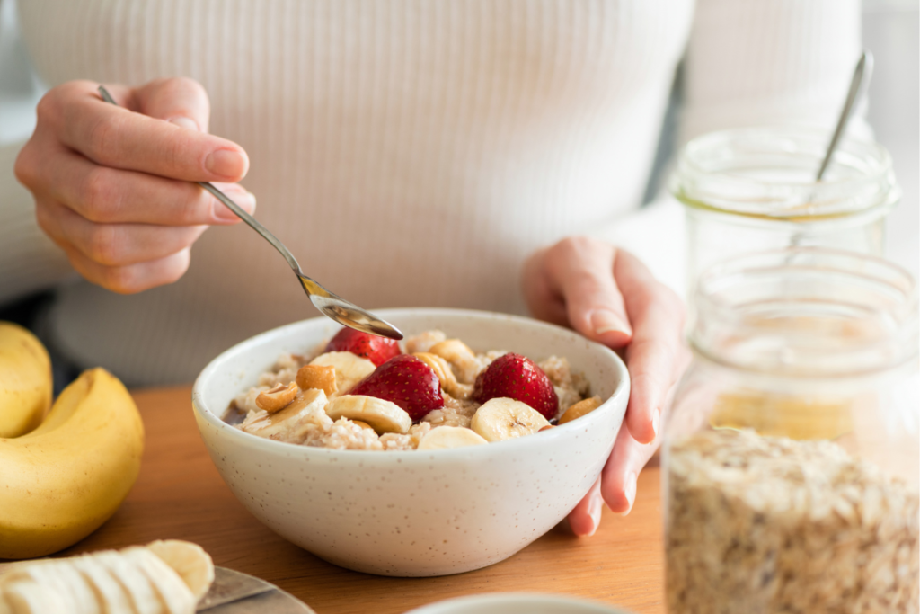 woman eating a bowl of porridge and fruit