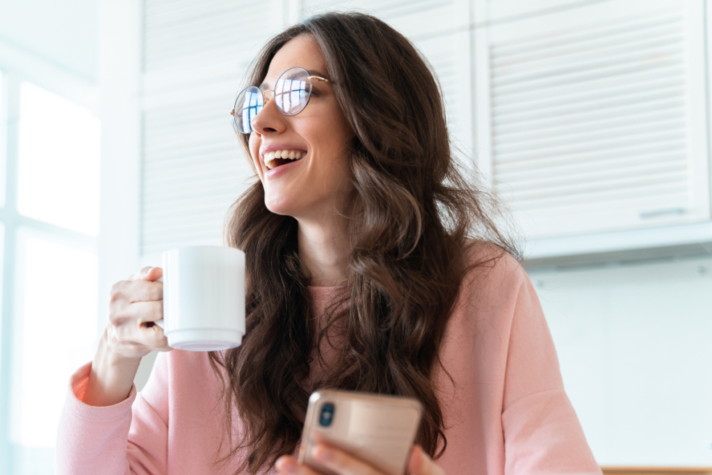 woman smiling and holding a mug
