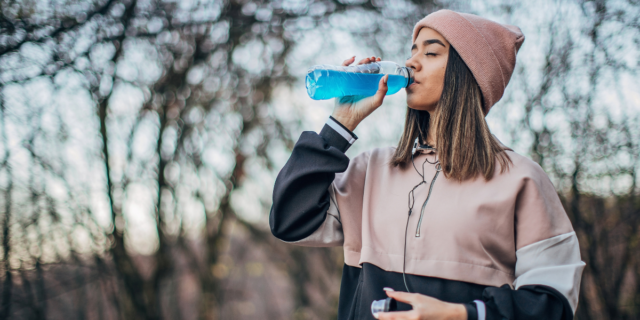 teenager girl drinking a blue energy drink