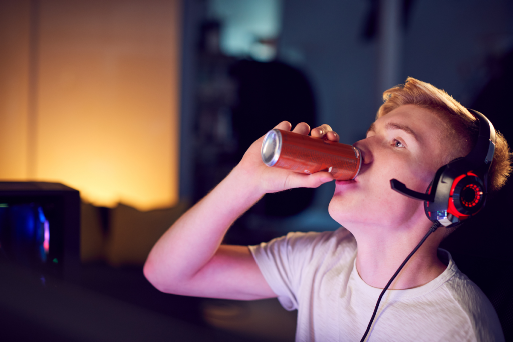 young man drinking red can of energy drink