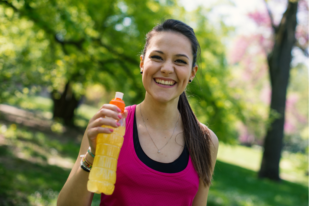 young woman holding orange energy drink