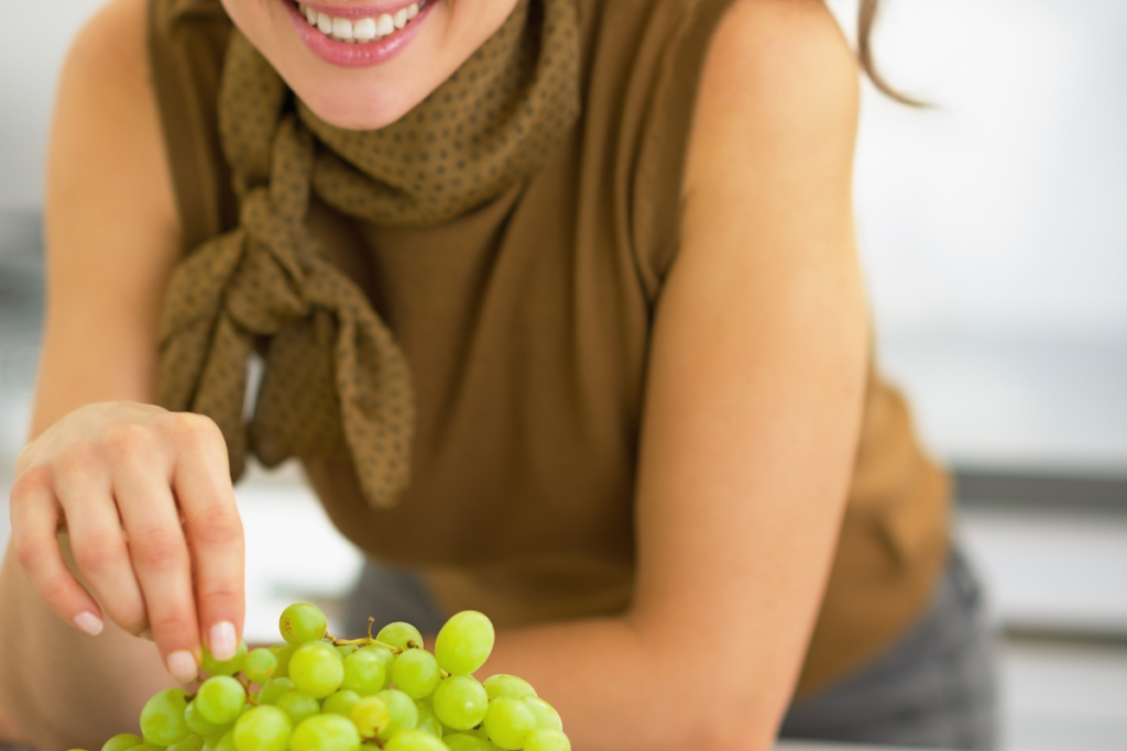woman snacking on grapes