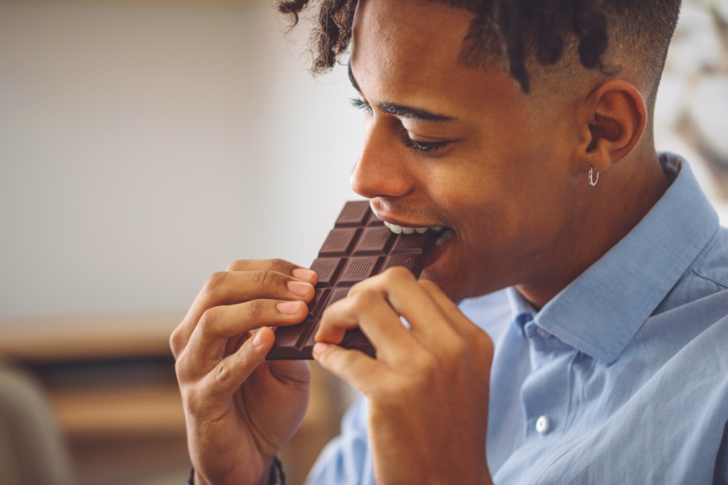 a man biting into a chocolate bar