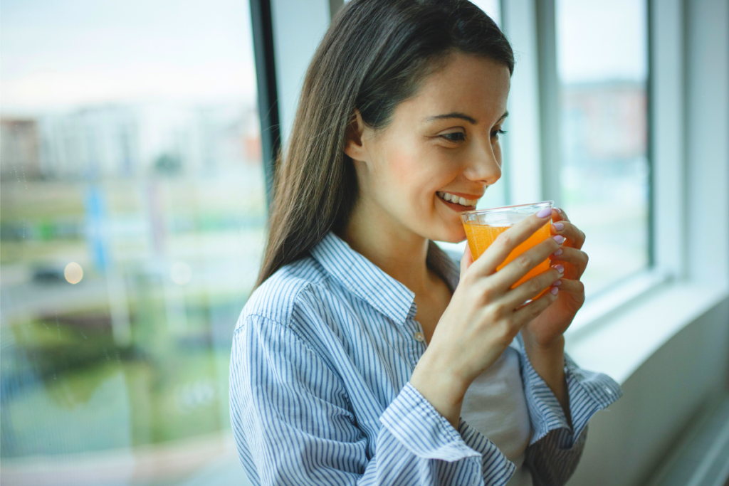 young woman drinking a glass of orange juice