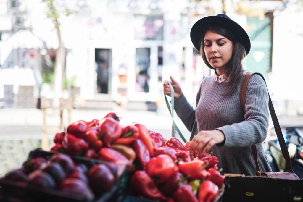 woman choosing red peppers at a market stall