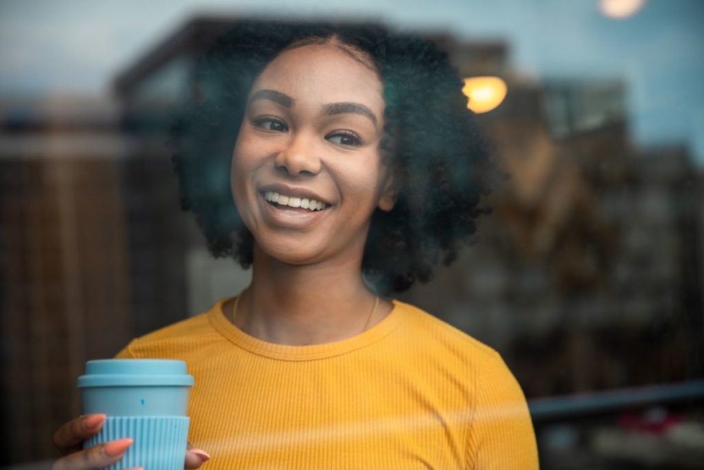 woman holding a reusable coffee cup