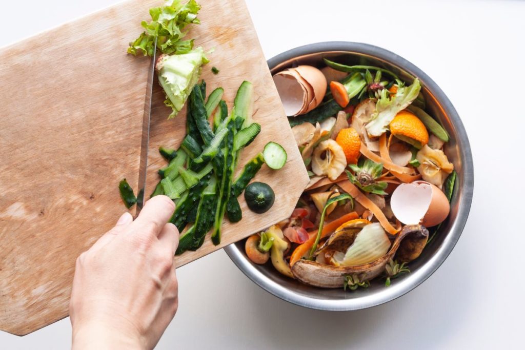 scraping food waste into compost bin