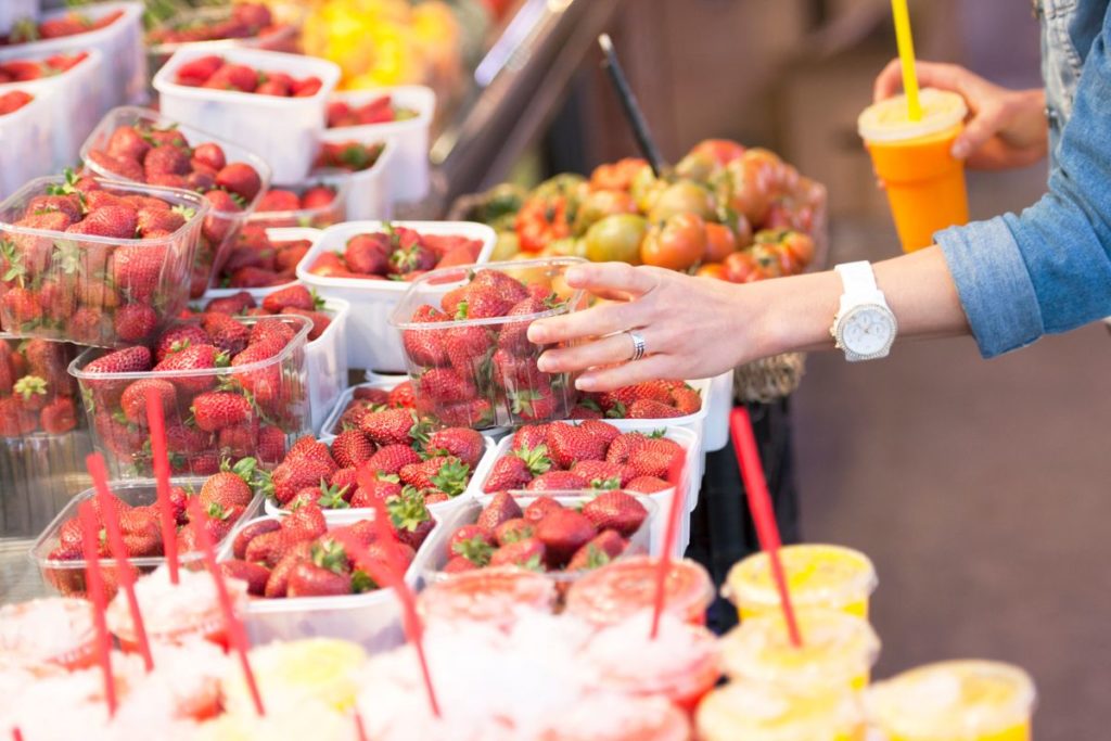 woman choosing a punnet of strawberries