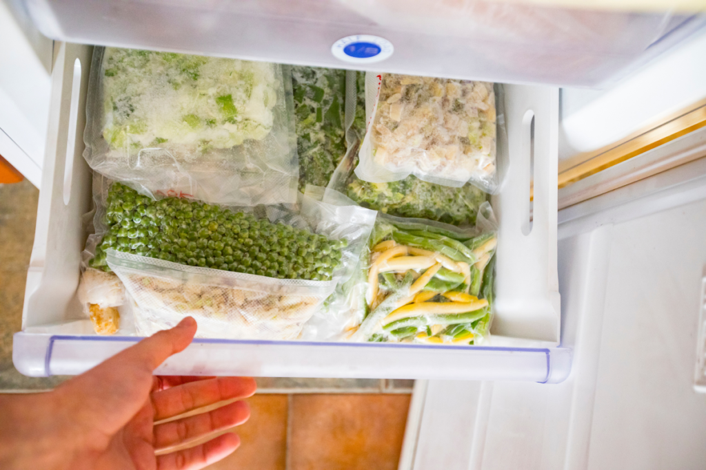 young man looking at frozen vegetables in freezer