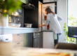 woman opening fridge to find ingredients