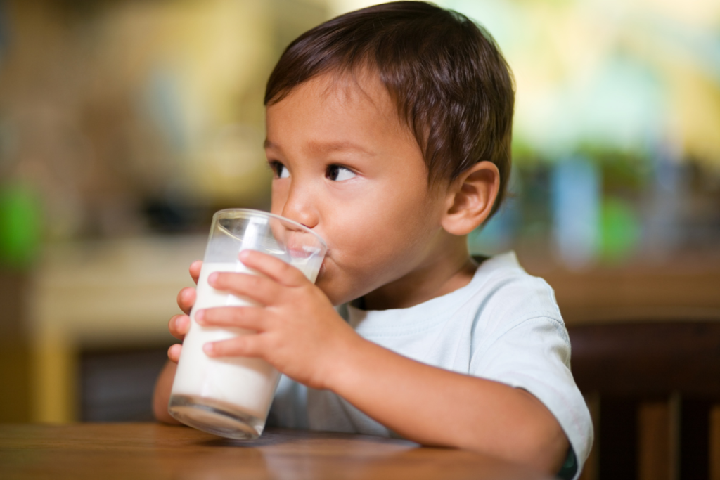 young boy drinking a glass of milk