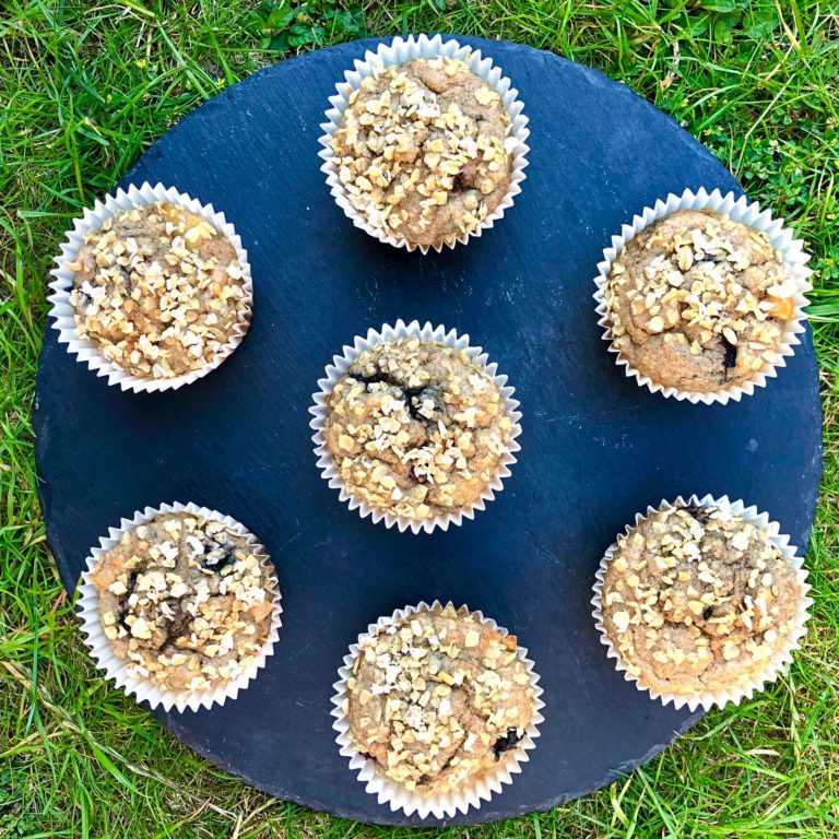 Banana, apple and blueberry muffins served on a slate chopping board