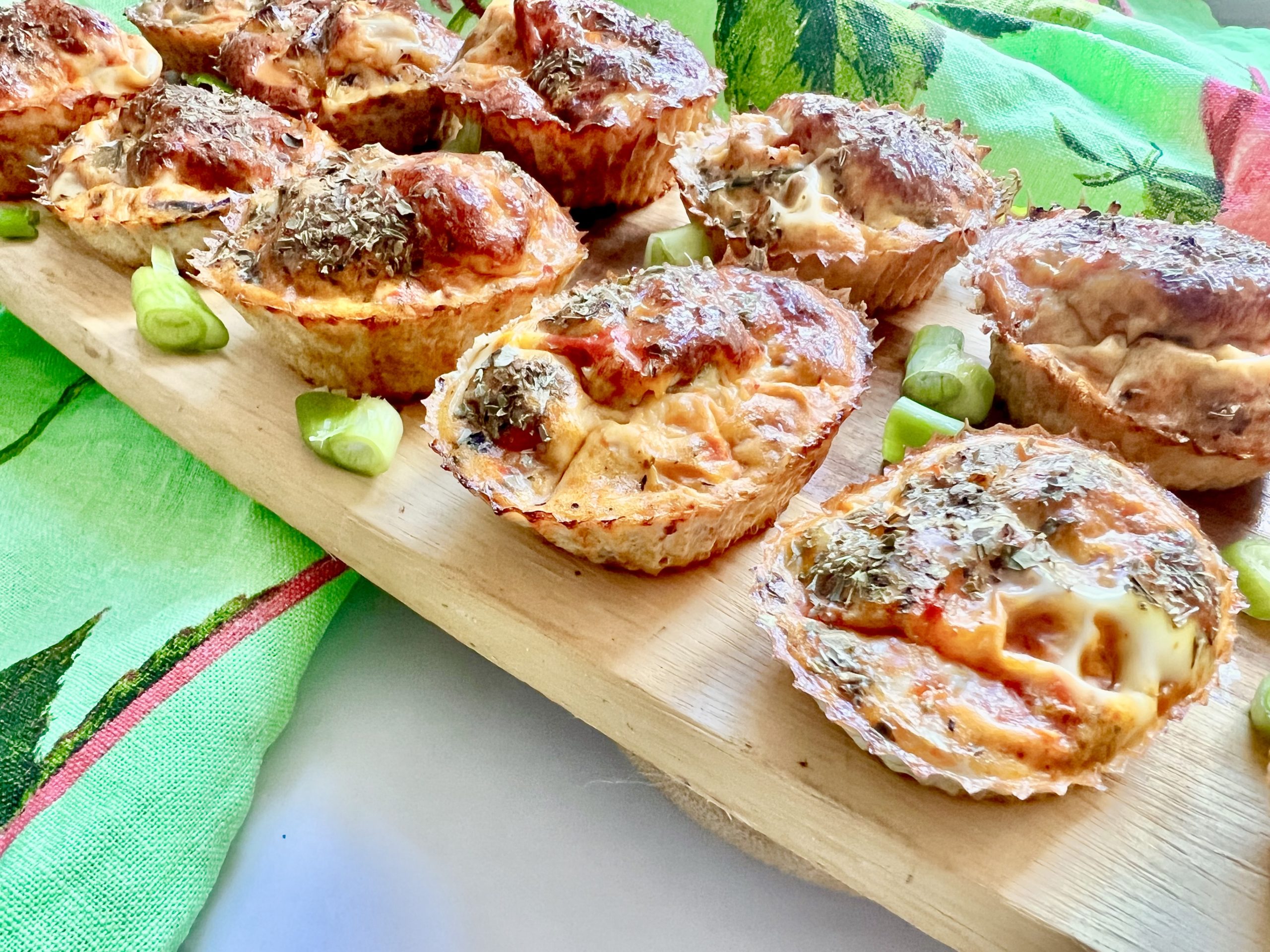 egg muffins on a wooden board with chopped spring onions