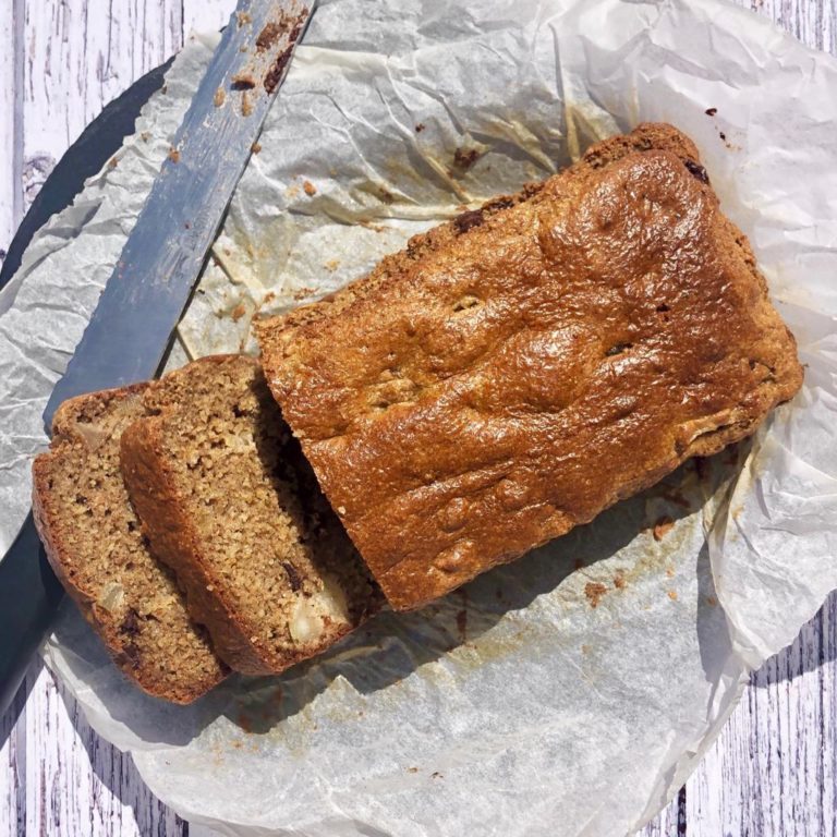Ginger and pear loaf on baking paper with 2 slices cut