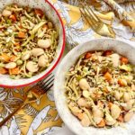 two bowls of plat-based stir fry on a table cloth next to a gold fork